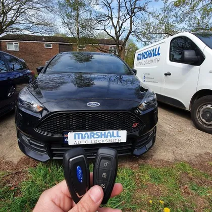 Auto locksmith cutting a replacement car key for a Ford in Cambridge